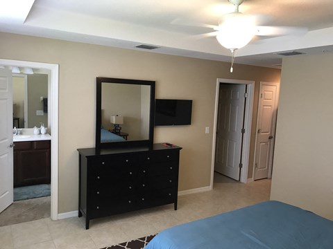 a bedroom with a bed and a dresser with a mirror