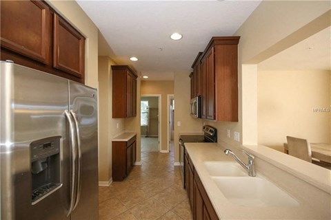 a kitchen with a stainless steel refrigerator and a sink