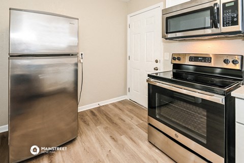 a kitchen with stainless steel appliances and a refrigerator