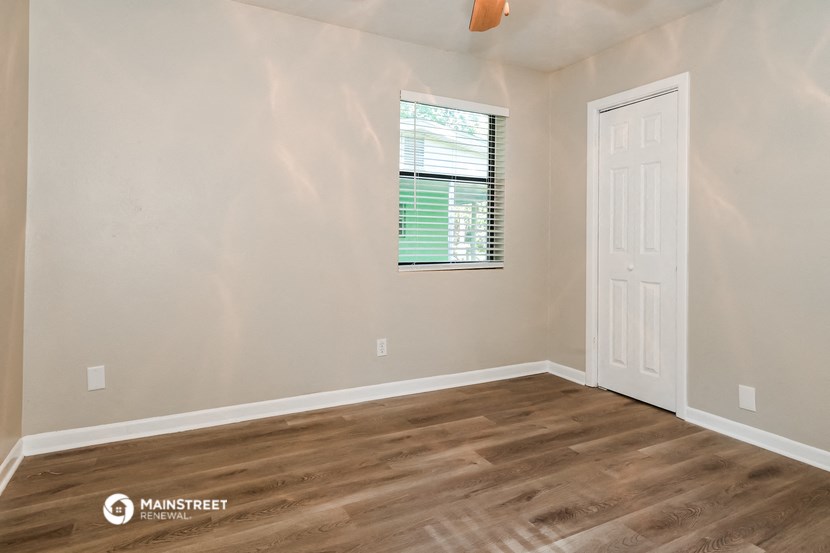 the bedroom of our studio apartment atrium with wood flooring and a window