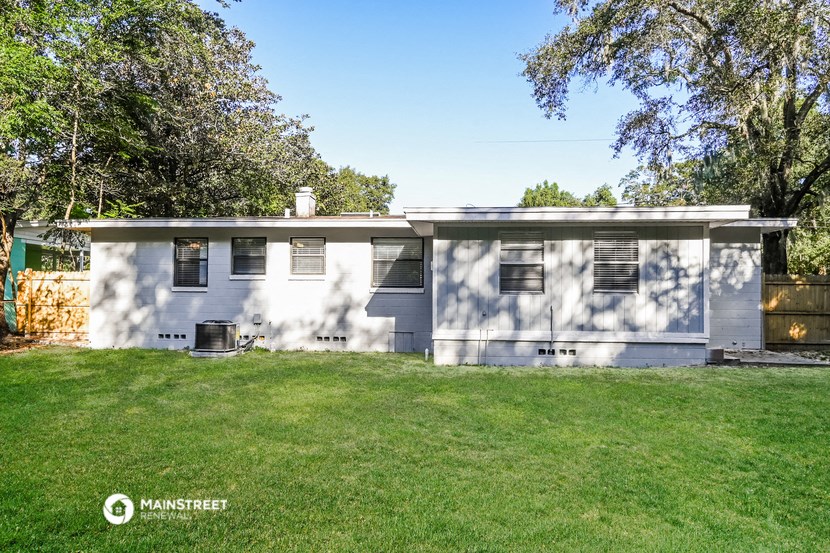 a white and gray house with a lawn in front of it