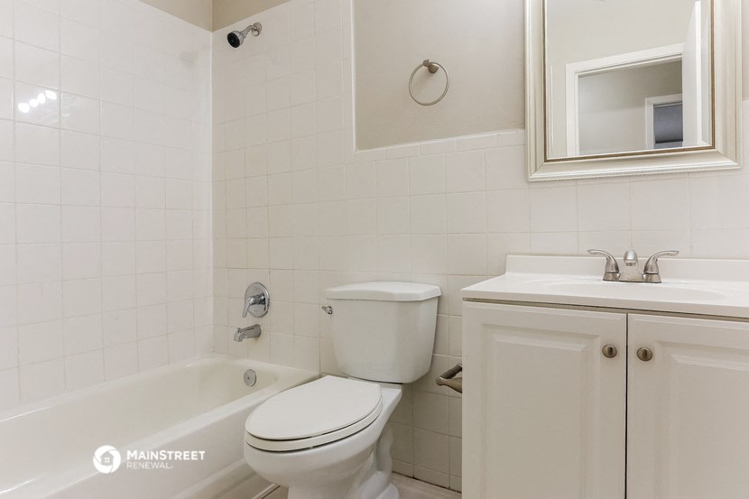 a bathroom with a toilet and a tub and a sink