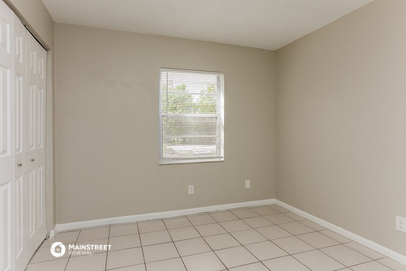 an empty room with a window and a tiled floor