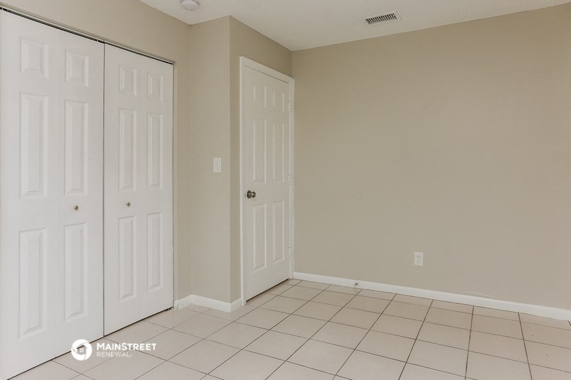 a bedroom with two closets and a tiled floor