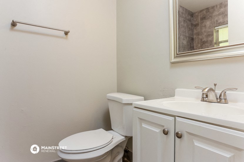 a bathroom with a toilet and a sink and a mirror