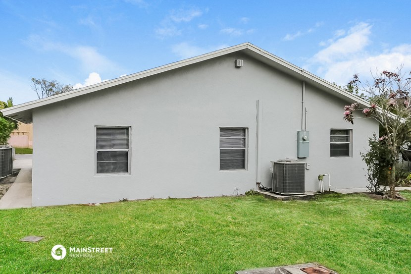 a white house with a green lawn and a blue sky