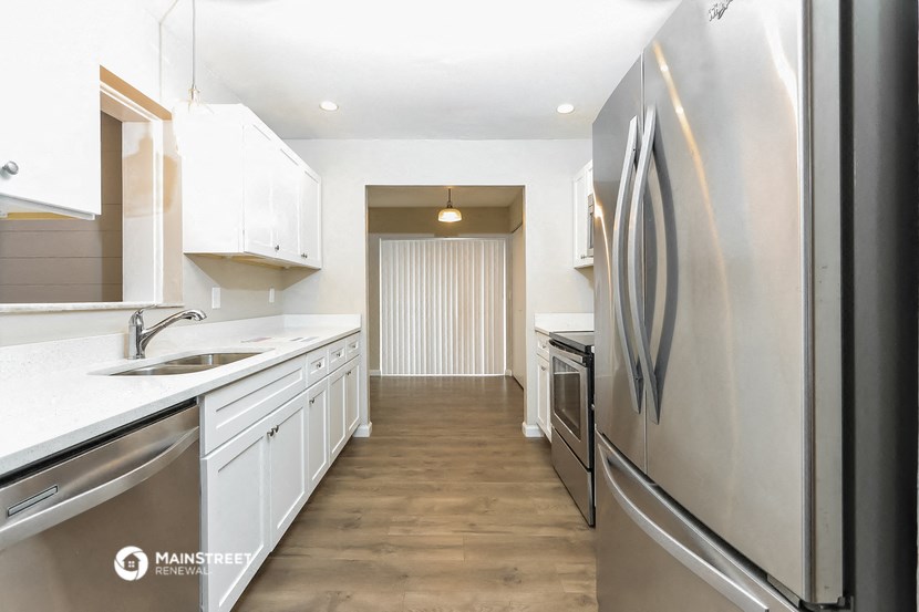 a large kitchen with white cabinets and stainless steel appliances