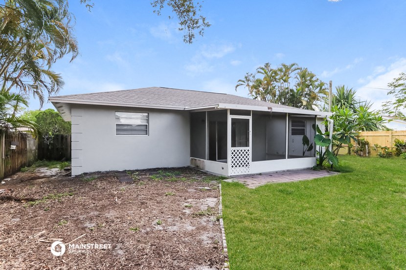 a small white house with a yard and a fence