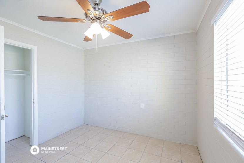 a room with a ceiling fan and a tiled floor