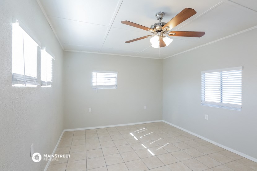 an empty room with a ceiling fan and a tiled floor