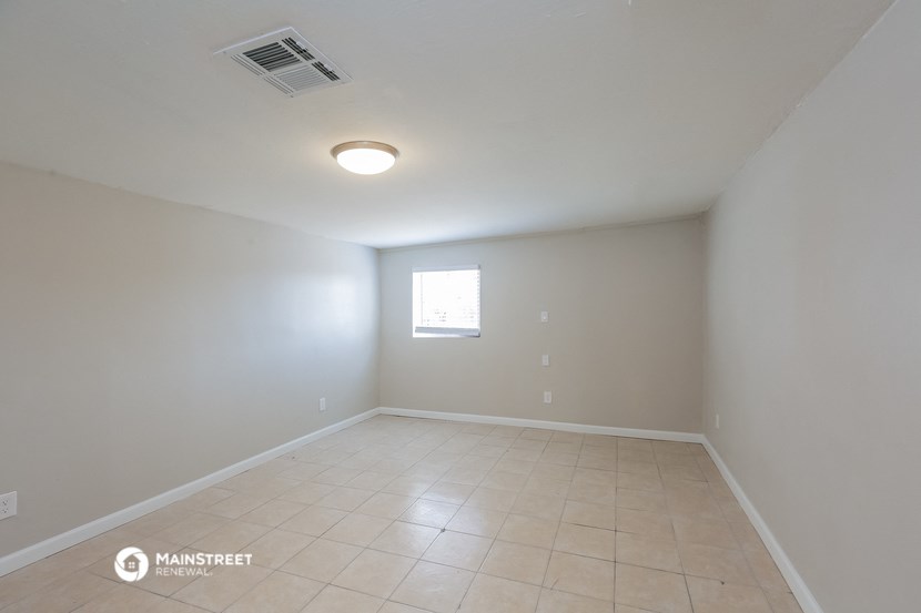 an empty room with white walls and a window