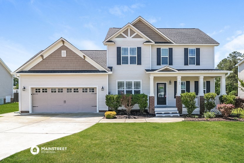 a white house with a lawn and a driveway
