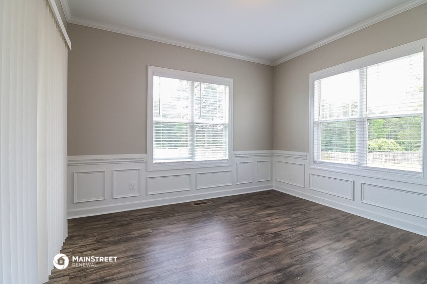 an empty living room with wood floors and windows