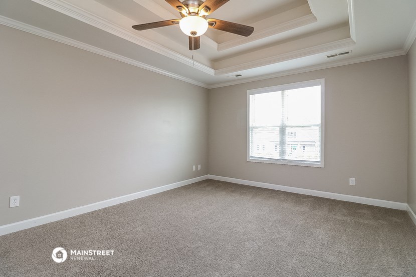 an empty room with a ceiling fan and a window