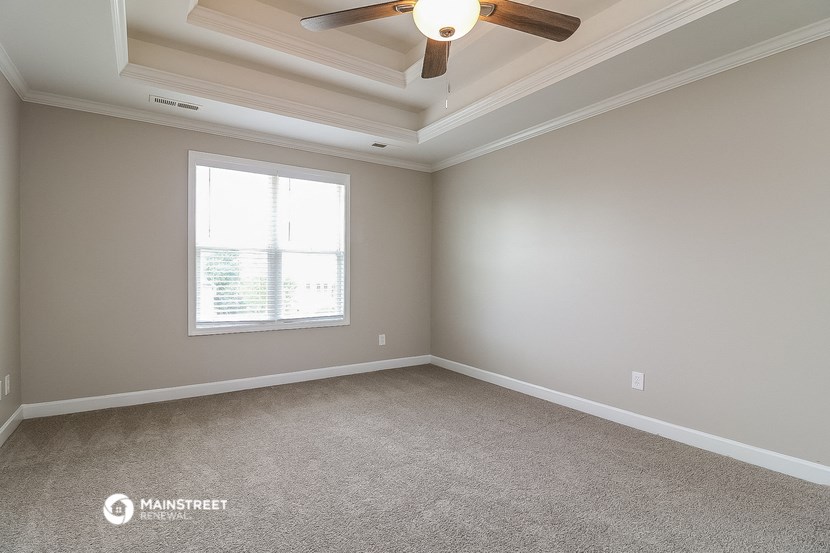 an empty room with a ceiling fan and a window
