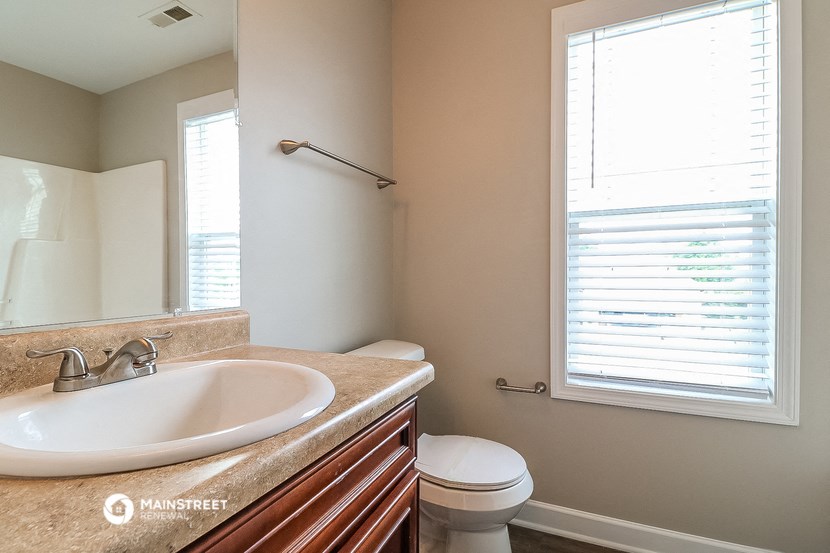 a bathroom with a sink and a toilet and a mirror