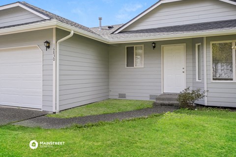 a white house with white siding and a lawn