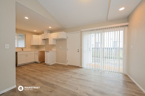 the living room and kitchen of an apartment with a large window