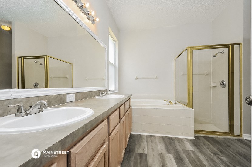 a bathroom with two sinks and a tub and a shower
