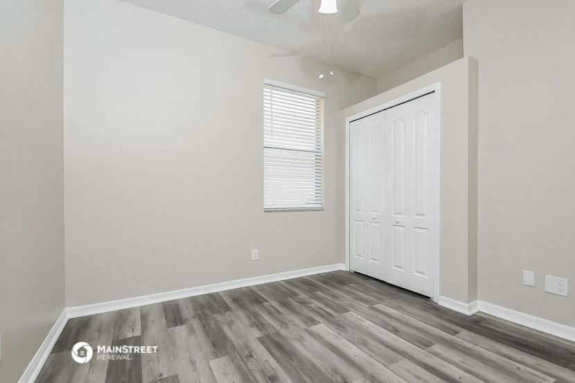 the interior of a bedroom with wood flooring and a white door