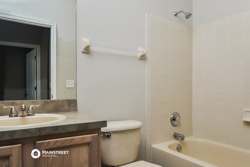 a bathroom with a sink toilet and tub and a mirror