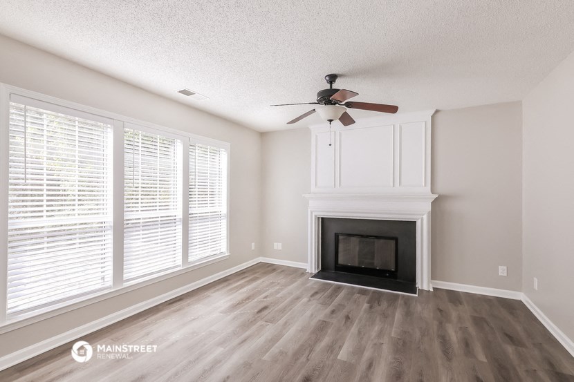 a living room with a fireplace and a ceiling fan