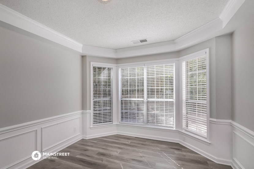 the living room of a new home with white plantation shuttered windows
