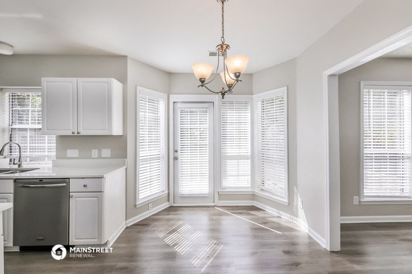 the kitchen and dining room of a new home with white plantation shutters