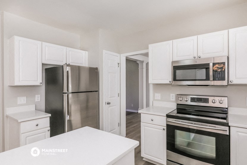 a kitchen with white cabinets and stainless steel appliances