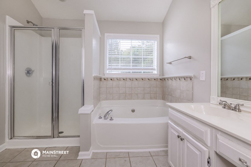 a bathroom with a tub and a shower and a sink