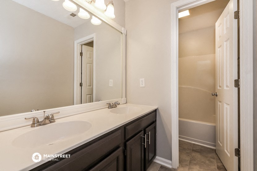 a bathroom with two sinks and a large mirror