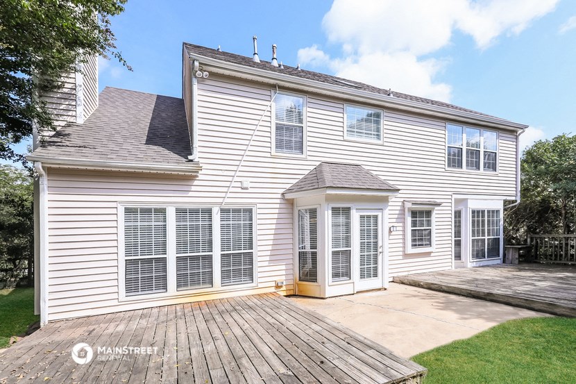 a white house with a wooden deck in front of it