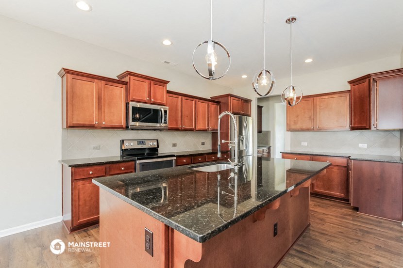 a kitchen with wooden cabinets and granite counter tops and a sink