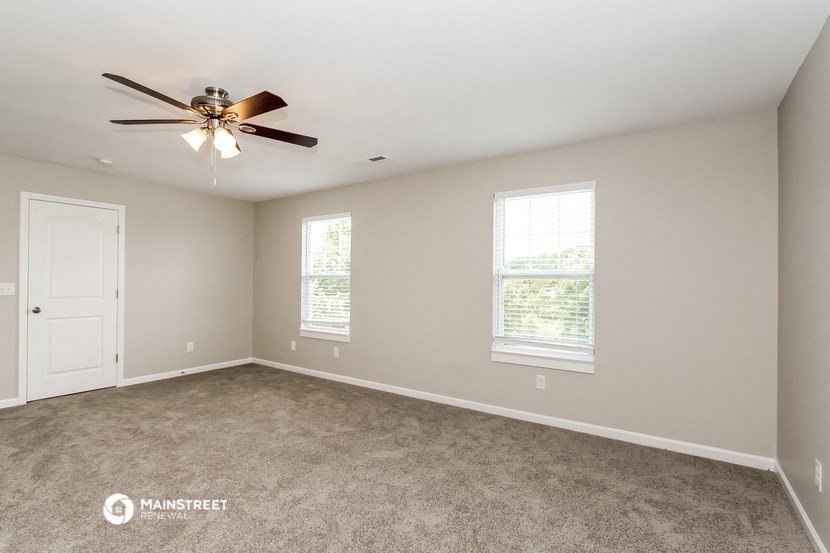 the master bedroom is spacious and has a ceiling fan