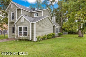 the front of a house with a yard and trees