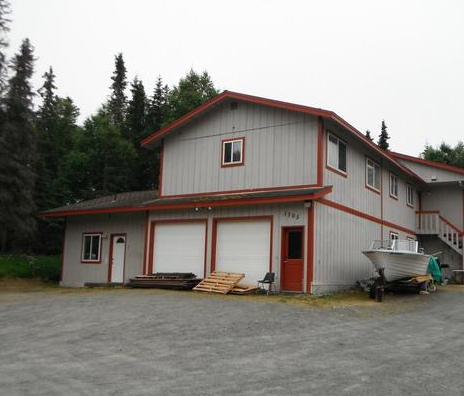 a white house with a boat parked outside of it