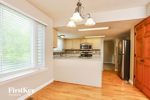 A kitchen with wooden floors and white appliances.