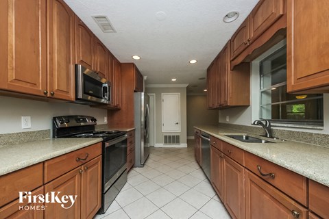 A kitchen with wooden cabinets and a FirstKey Homes logo.