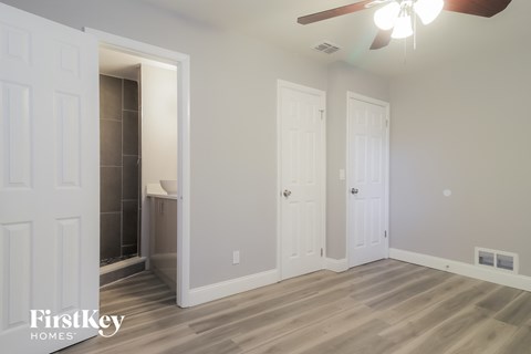 a clean and empty living room with a ceiling fan