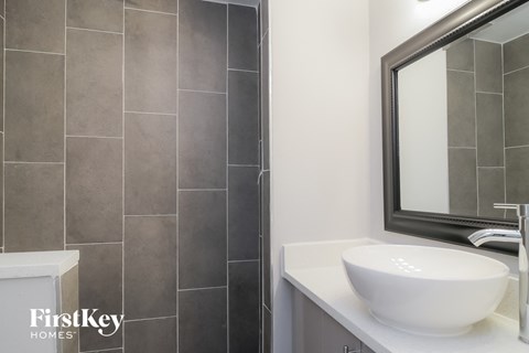 a bathroom with a sink and a shower and a mirror