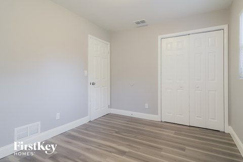 a bedroom with two white doors and a wood floor