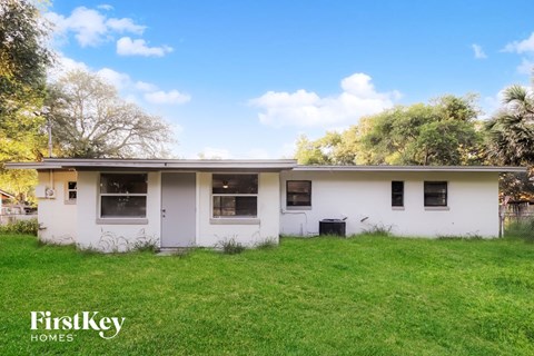 a small white house with a grassy yard in front of it