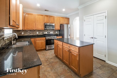 A kitchen with wooden cabinets and a black countertop.