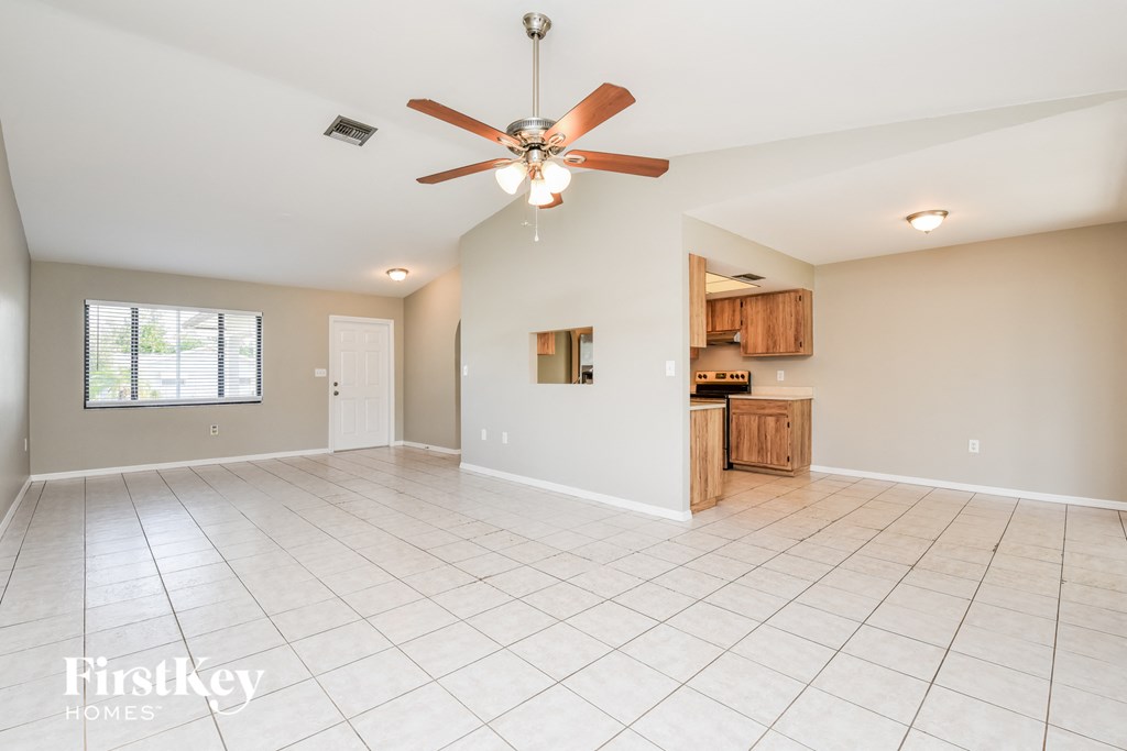 A spacious room with a ceiling fan and tiled flooring.