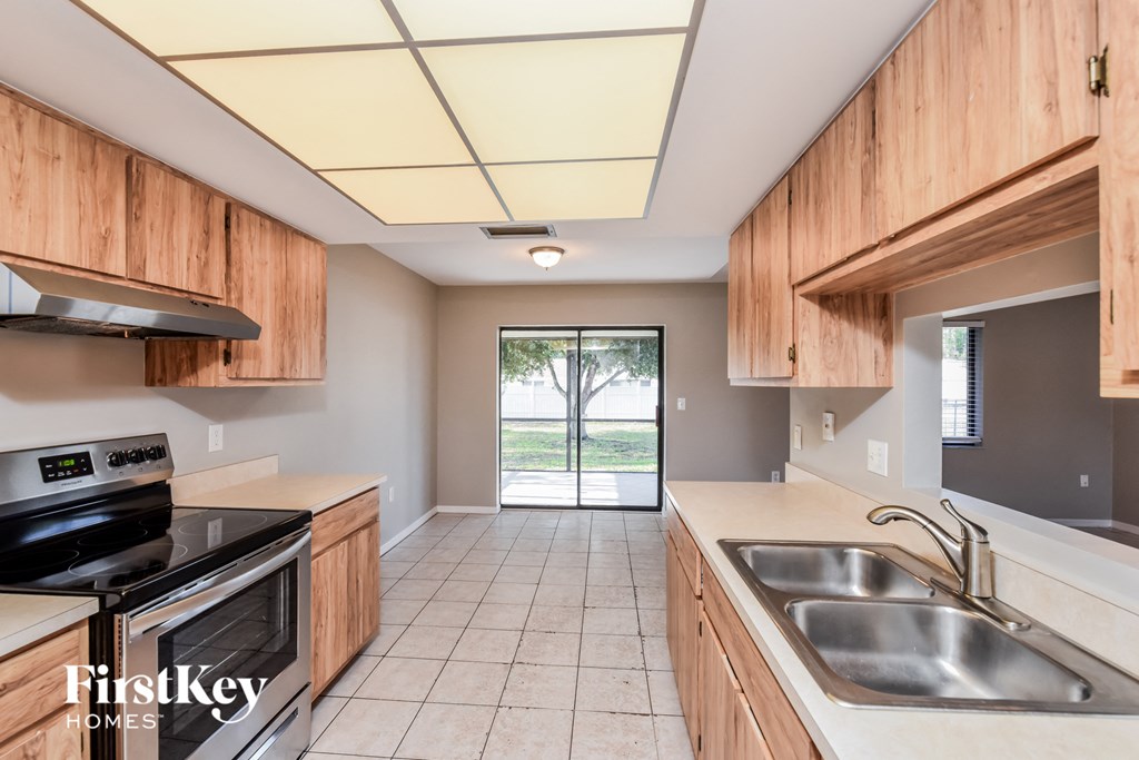 A kitchen with wooden cabinets and a stainless steel sink.
