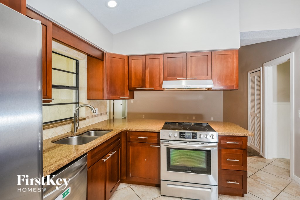 a kitchen with wooden cabinets and stainless steel appliances