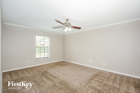 a living room with carpet and a ceiling fan