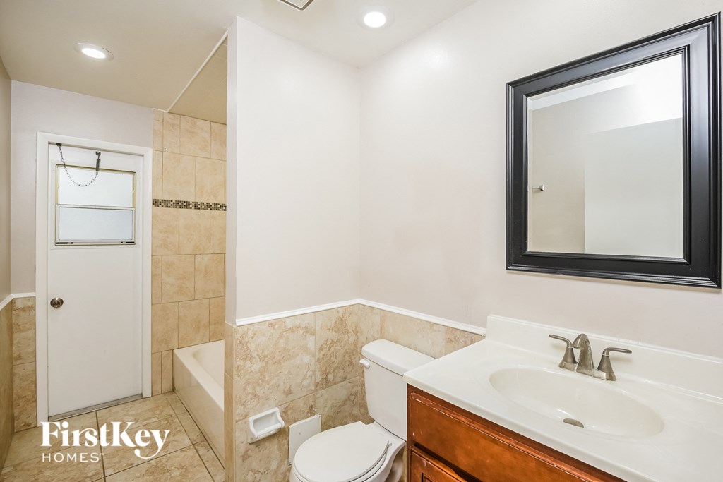 a bathroom with a sink toilet and a mirror