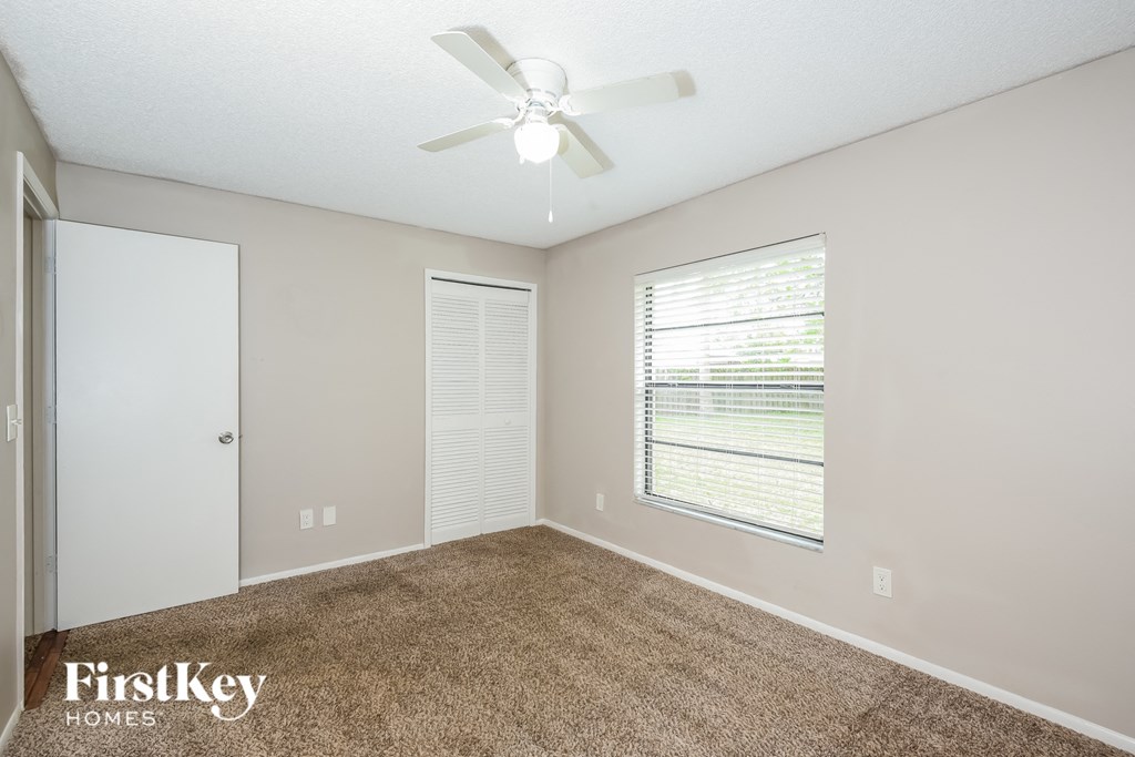 a bedroom with a ceiling fan and a window
