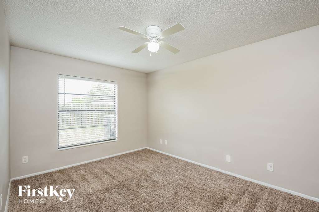a bedroom with a ceiling fan and a window